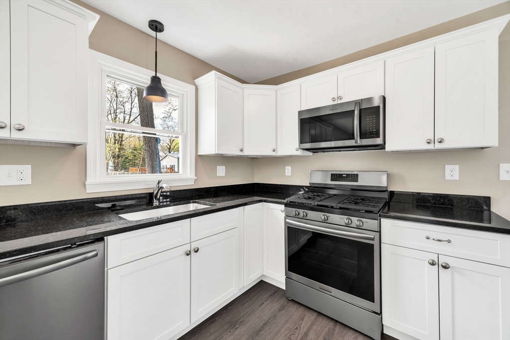 230 Gilbert Avenue Springfield, MA 01119 - Photo 9 of 40 a kitchen with granite countertop white cabinets white appliances a sink and a window