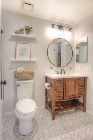 a bathroom with a toilet a sink and a mirror