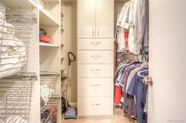 a view of walk in closet with clothes and shoes