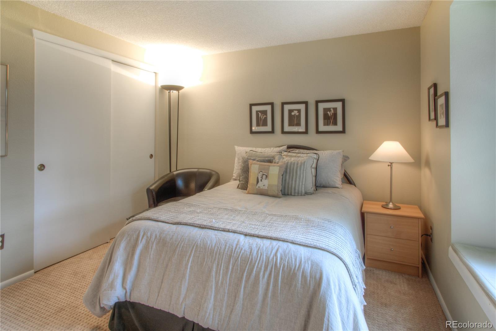 11703 West Elk Head Range Road Littleton, CO 80127 - Photo 23 of 46 a bedroom with a bed and a lamp
