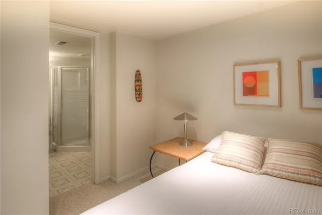 a bedroom with a bed and painting on the wall