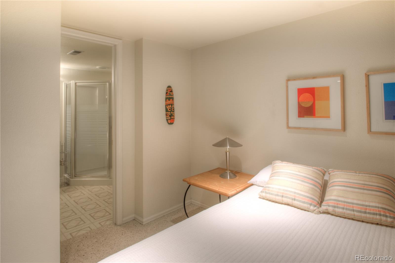 11703 West Elk Head Range Road Littleton, CO 80127 - Photo 31 of 46 a bedroom with a bed and painting on the wall