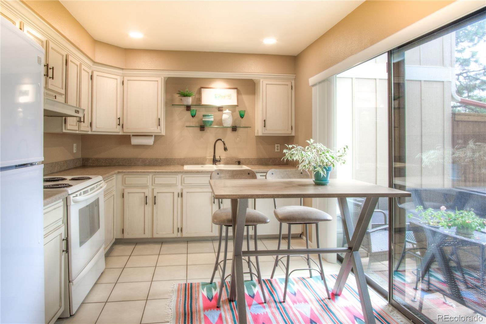 11703 West Elk Head Range Road Littleton, CO 80127 - Photo 9 of 46 a kitchen with a table chairs sink and cabinets