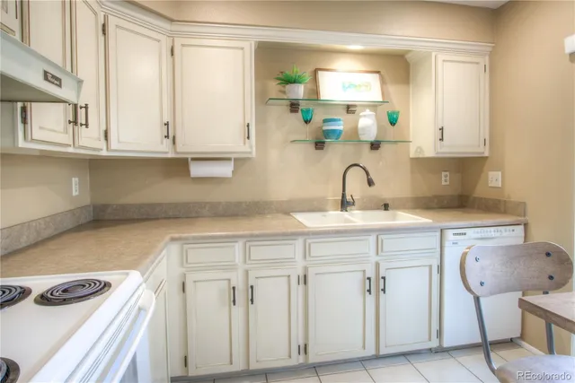 a kitchen with white cabinets and sink