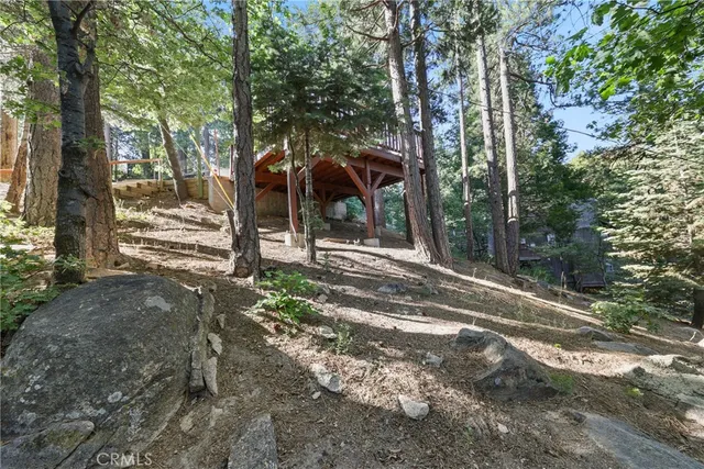 a view of a park that has large trees and a wooden fence