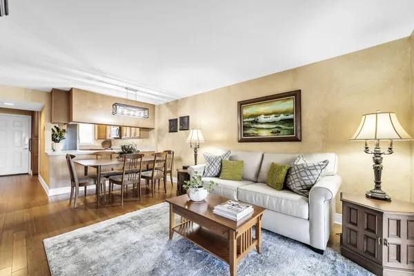 a living room with furniture wooden floor and a table