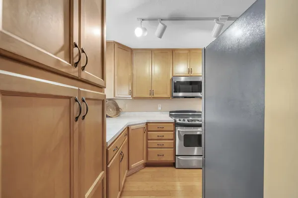 a kitchen with stainless steel appliances granite countertop a sink a stove and refrigerator