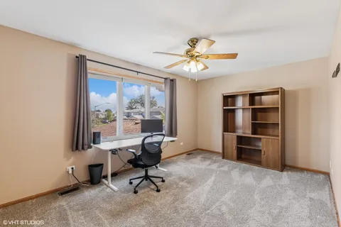 a view of a workspace with furniture and a window