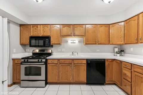a kitchen with a sink stove top oven and cabinets