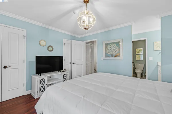a bedroom with a bed and a flat tv screen on dresser