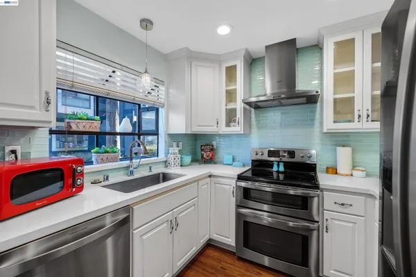 a kitchen with stainless steel appliances granite countertop a refrigerator and a stove