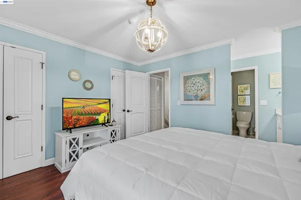 a bedroom with a bed and a flat tv screen on dresser