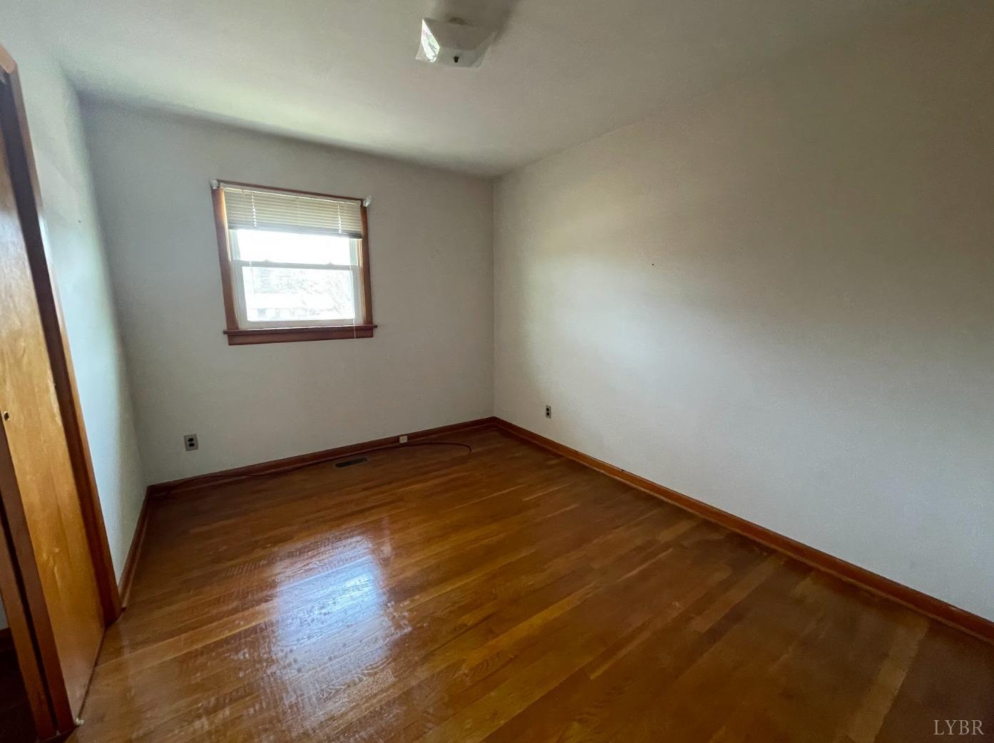363 Lynbrook Road Rustburg, VA 24588 - Photo 11 of 19 an empty room with wooden floor and windows