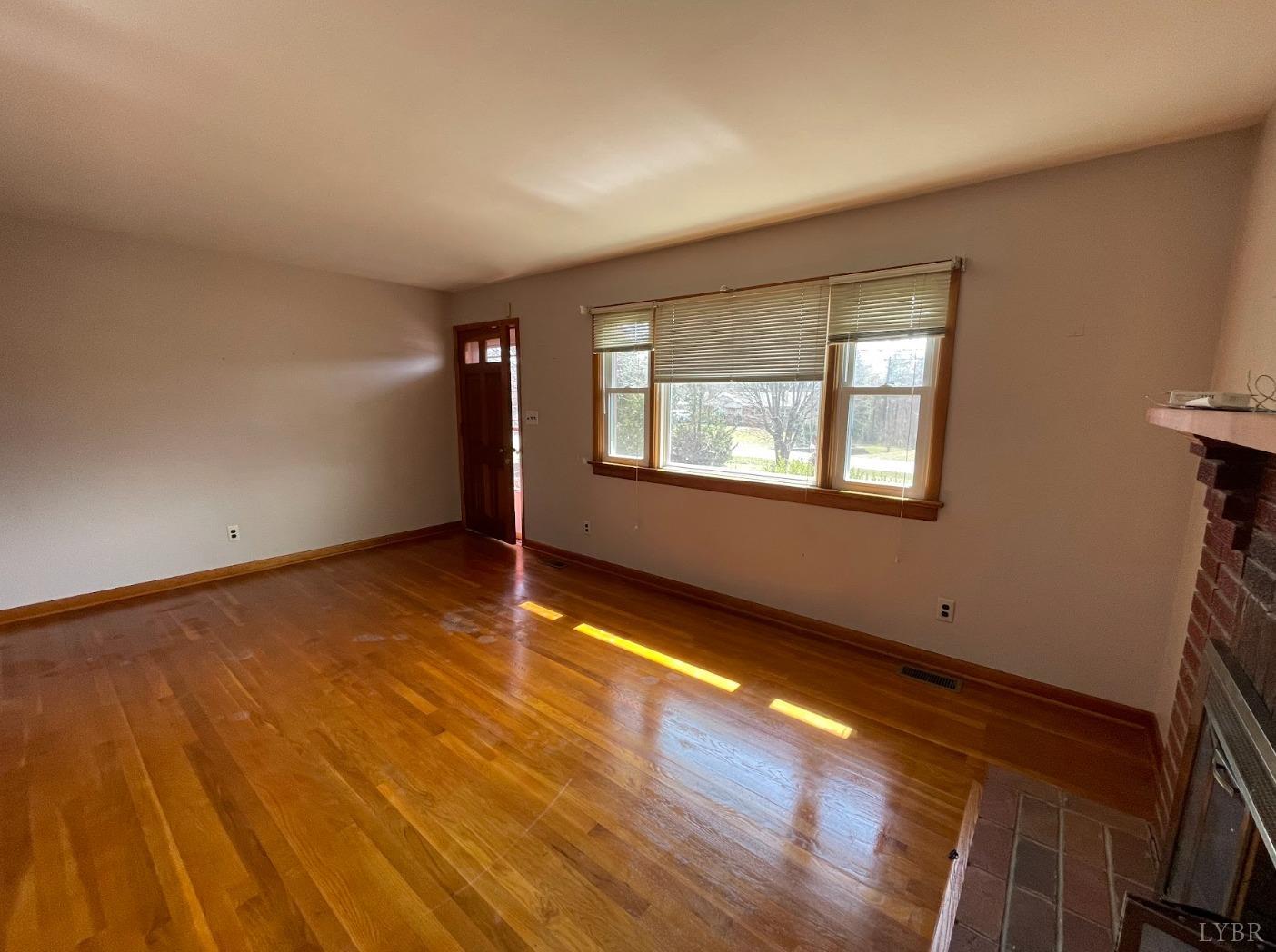 363 Lynbrook Road Rustburg, VA 24588 - Photo 2 of 19 a view of an empty room with wooden floor and a window