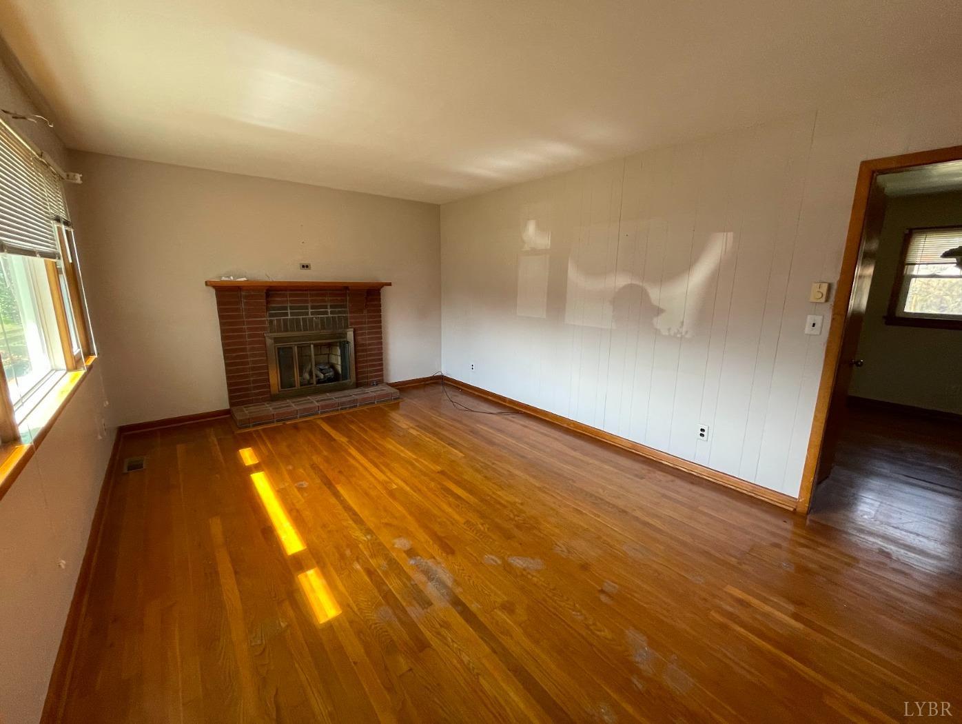 363 Lynbrook Road Rustburg, VA 24588 - Photo 3 of 19 an empty room with wooden floor and windows