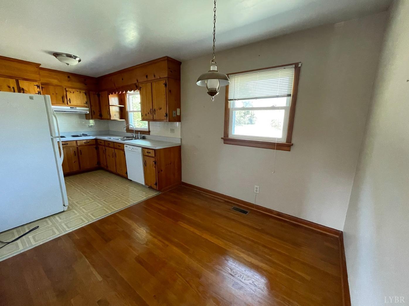 363 Lynbrook Road Rustburg, VA 24588 - Photo 4 of 19 a kitchen with stainless steel appliances granite countertop a refrigerator a sink dishwasher a stove and white countertops with wooden floor