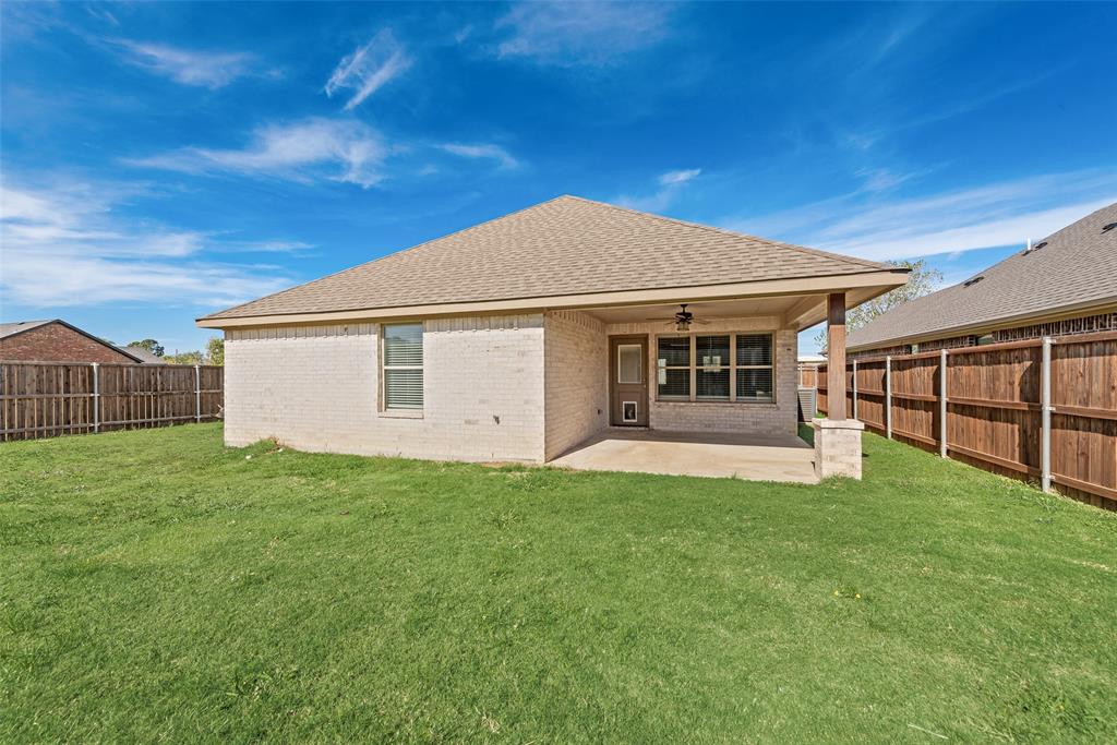 625 Copenhavr Street Pilot Point, TX 76258 - Photo 19 of 20 Back of house featuring brick siding, a shingled roof, a ceiling fan, a patio area, and a fenced backyard