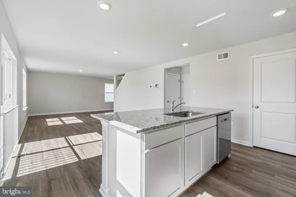 a kitchen with granite countertop a sink and a stove top oven