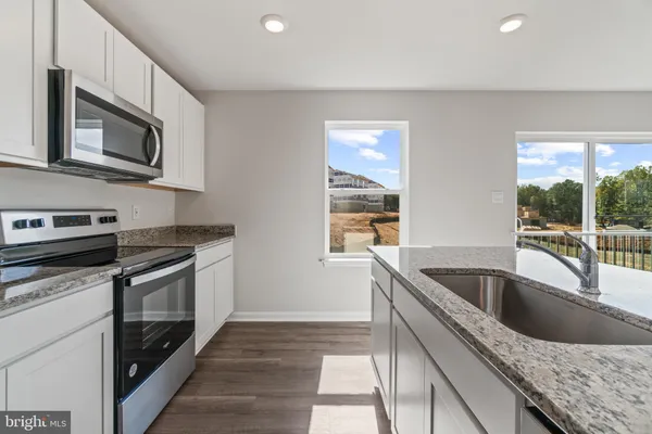 a kitchen with granite countertop a sink and a microwave