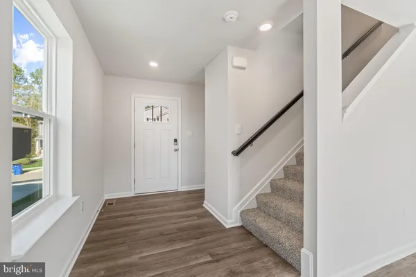a view of entryway and hall with wooden floor