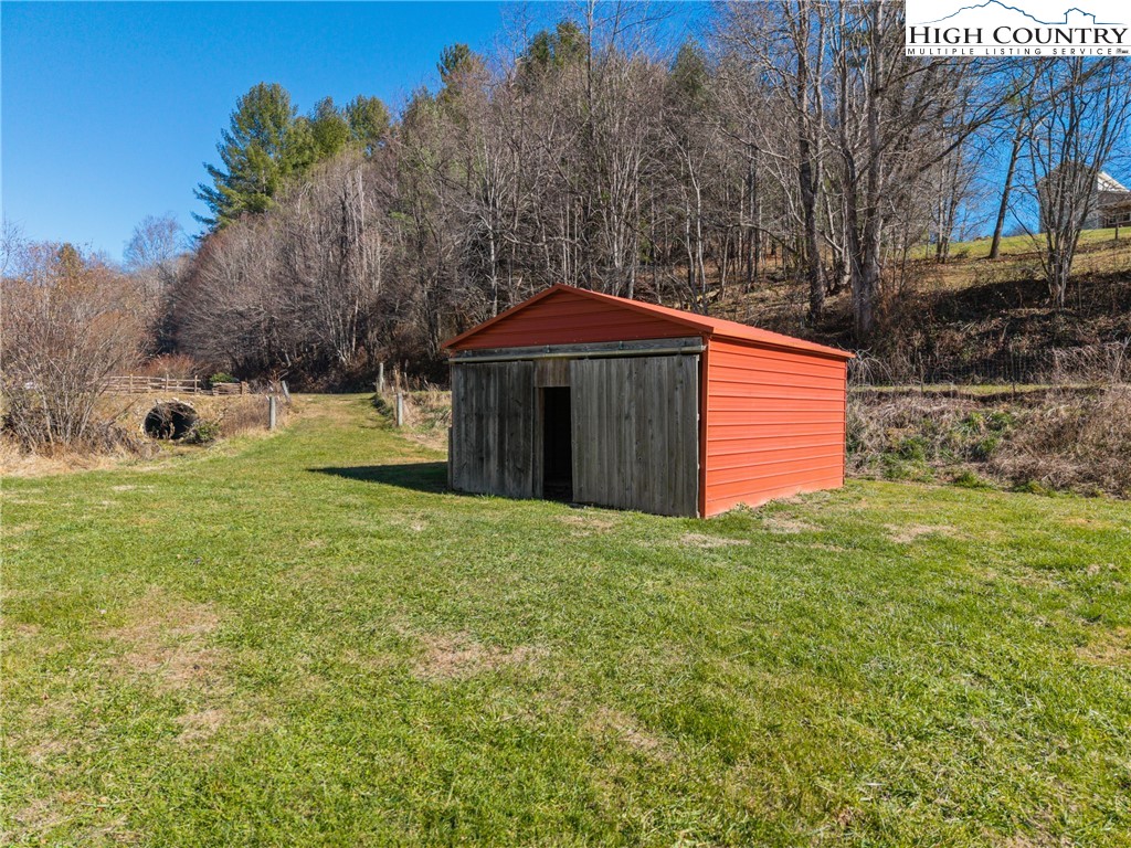 183 Laurel Branch Road Vilas, NC 28692 - Photo 35 of 39 a yellow house with a big yard and large trees