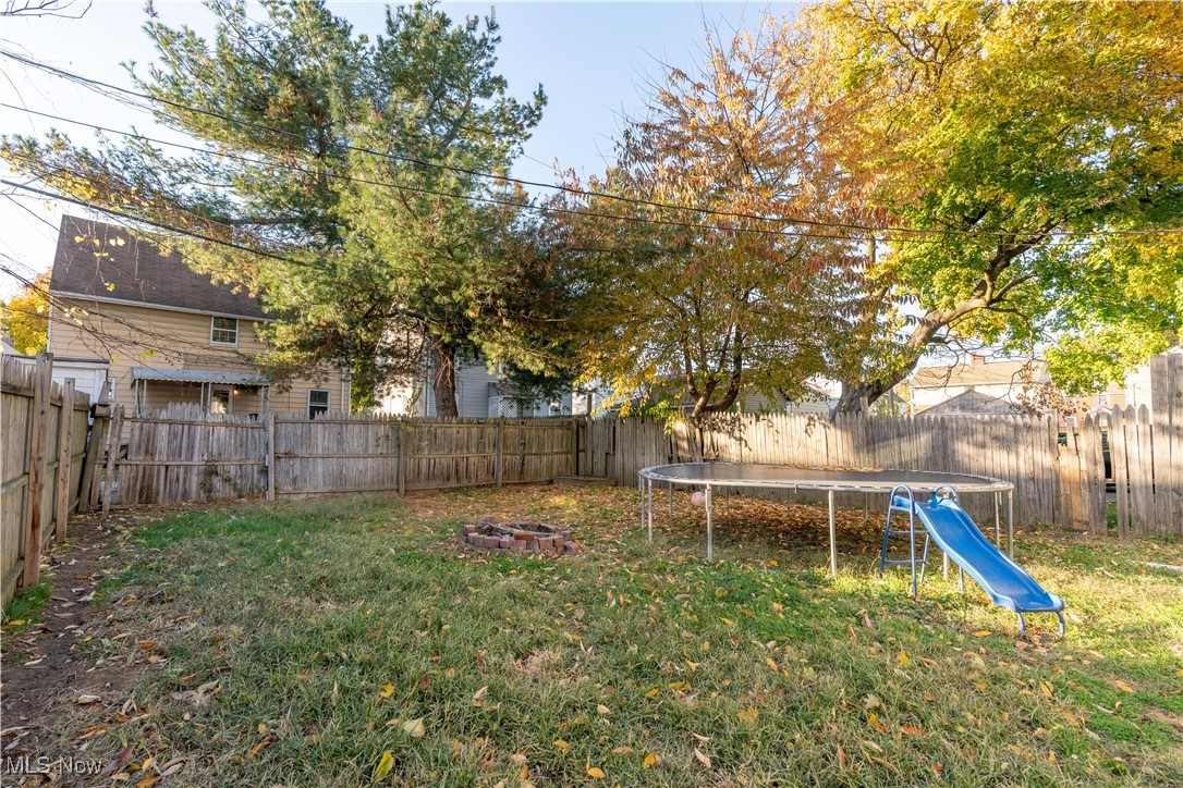 1361 Crescent Road Southwest Canton, OH 44710 - Photo 33 of 36 Fenced backyard featuring a trampoline and a fire pit