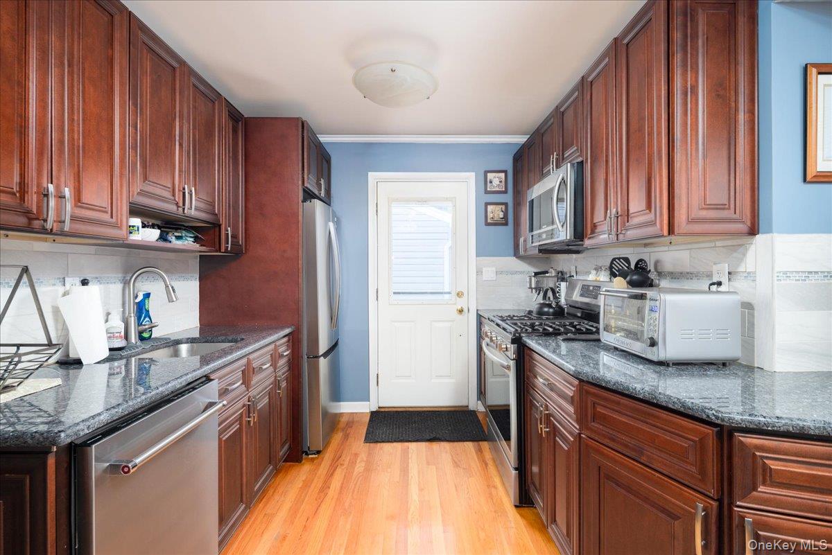 11 Adelphi Road Hicksville, NY 11801 - Photo 4 of 26 a kitchen with granite countertop stainless steel appliances a sink dishwasher refrigerator stove and cabinets