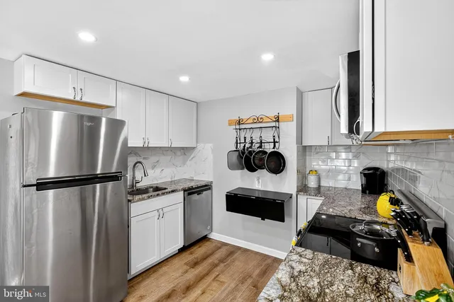 a kitchen with a refrigerator and a stove top oven