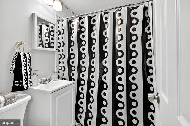 a bathroom with a sink and mirror with shower