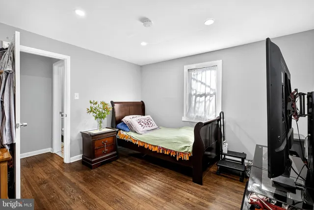 a bedroom with a bed and a flat tv screen on a dresser