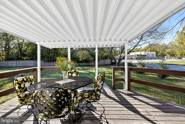 a view of a patio with table and chairs potted plants with wooden floor and fence