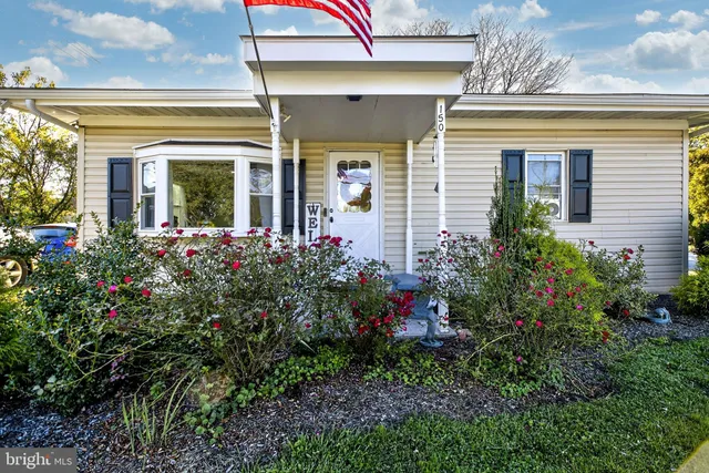 a view of a house that has a flower garden
