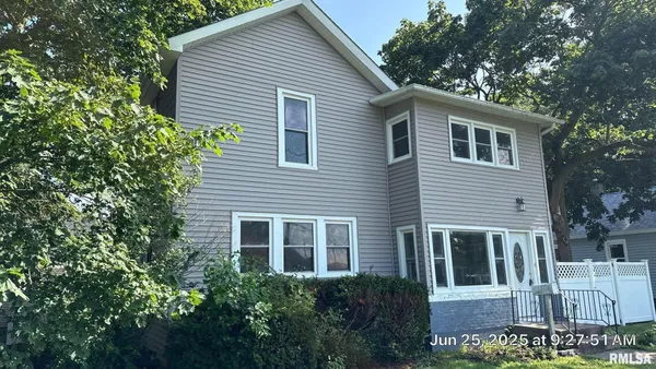 a view of a house with a yard and potted plants