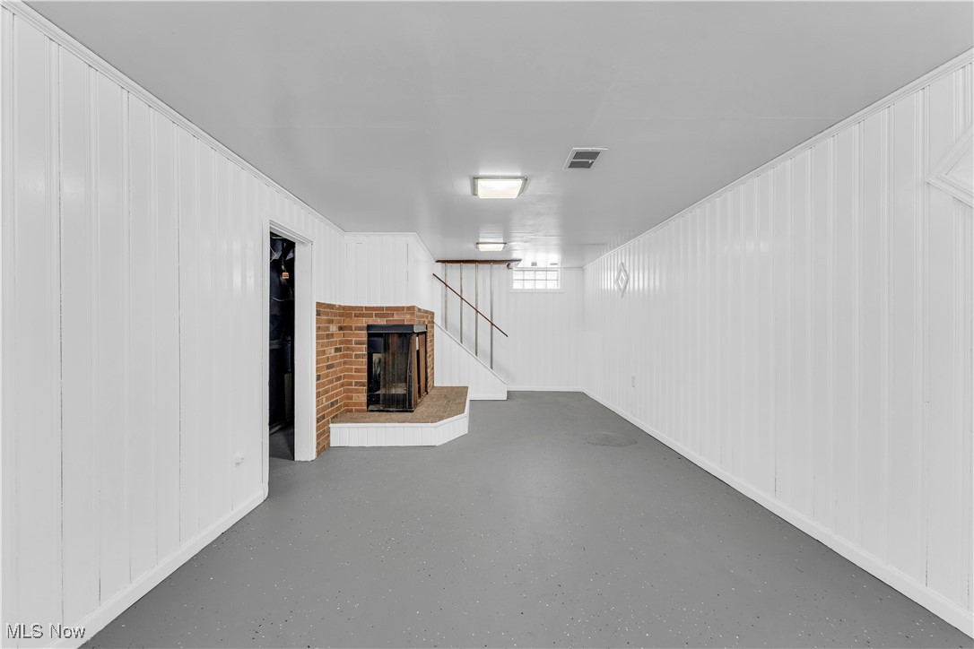 4693 Liberty Road South Euclid, OH 44121 - Photo 27 of 33 Finished basement featuring a brick fireplace, wood walls, and a decorative wall