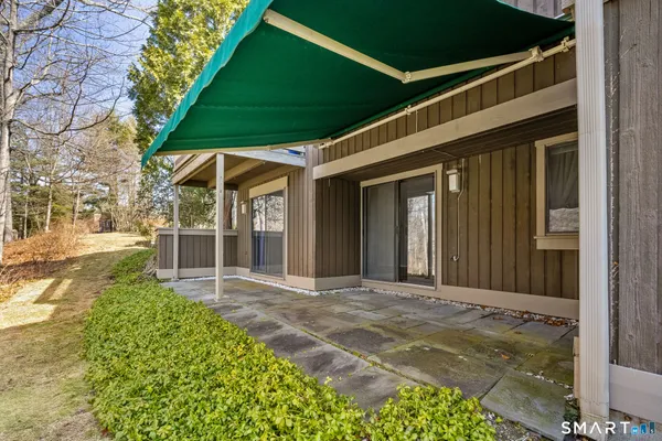 a view of a house with a yard and floor to ceiling windows
