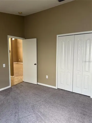 a backyard of a house with table and chairs plants and large tree