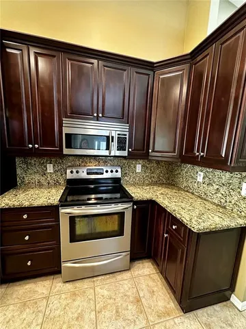 a kitchen with stainless steel appliances granite countertop wooden cabinets a sink and dishwasher