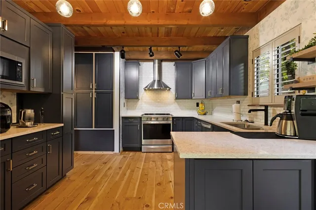 a kitchen with stainless steel appliances granite countertop a sink a stove and a refrigerator