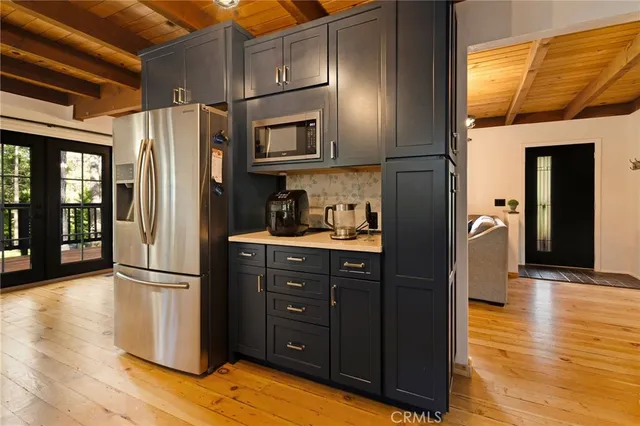 a kitchen with stainless steel appliances granite countertop a refrigerator and a wooden floors