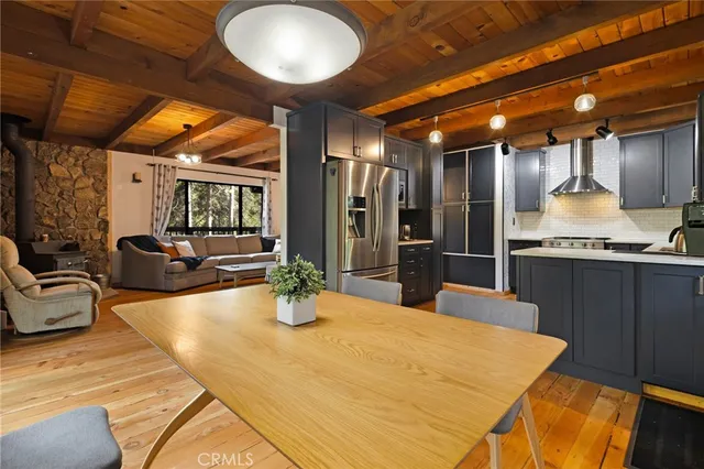 a kitchen with stainless steel appliances kitchen island granite countertop a table chairs in it and wooden floors