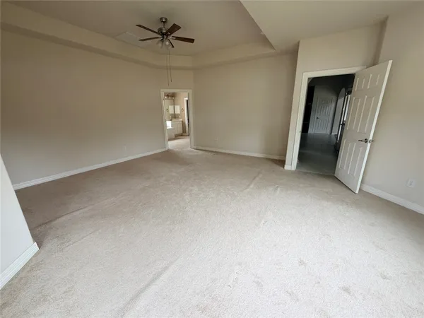 an empty room with a ceiling fan and window