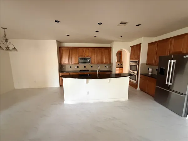 a kitchen with stainless steel appliances granite countertop a refrigerator and a stove