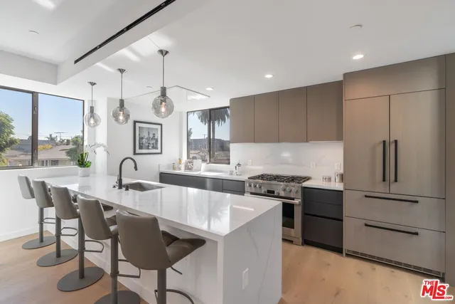 a kitchen with granite countertop a sink stainless steel appliances and window