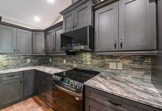 a kitchen with granite countertop a sink and cabinets