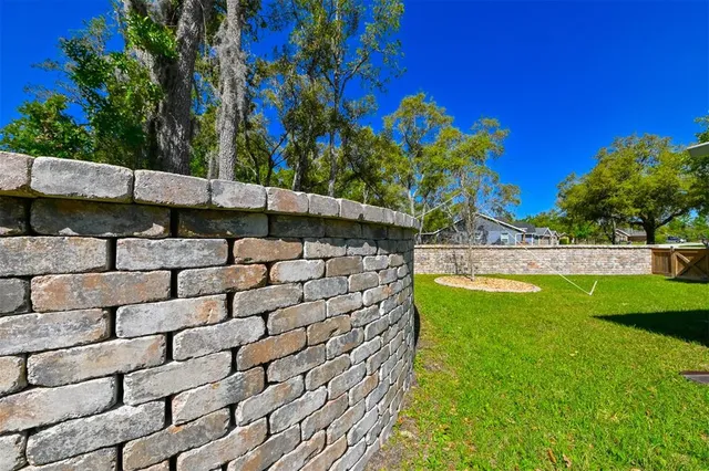 a view of a yard with wooden fence