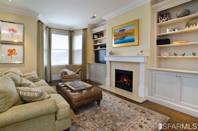 Living room with Gas Fireplace with marble surround flanked by bookcases.