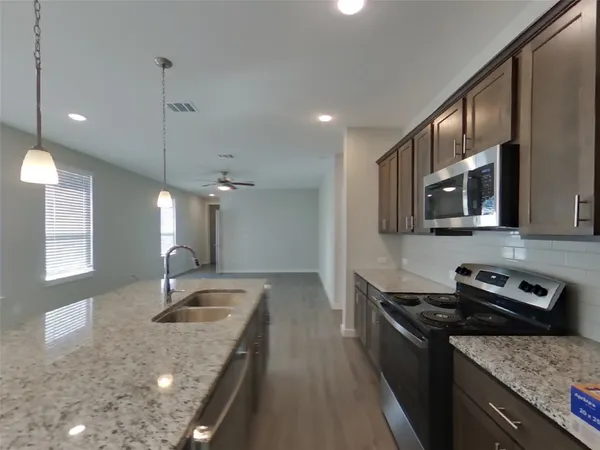 a kitchen with stainless steel appliances granite countertop a sink stove and refrigerator