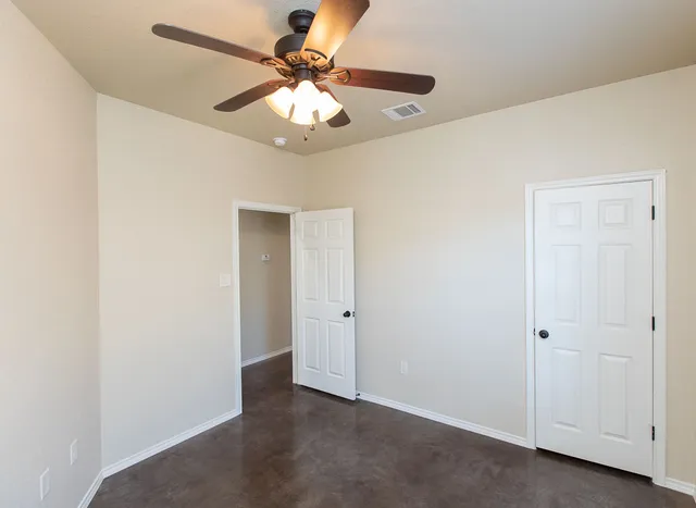 an empty room with a chandelier fan and a chandelier fan