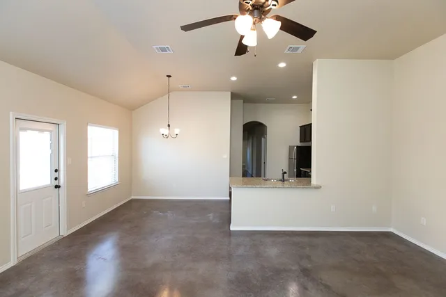 a view of a big room with chandelier fan and windows