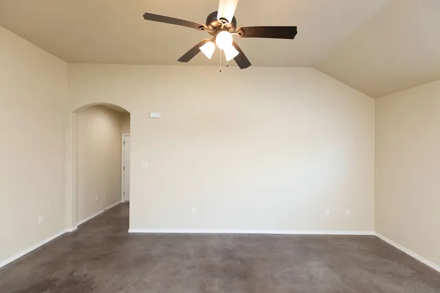 an empty room with closet and a chandelier fan